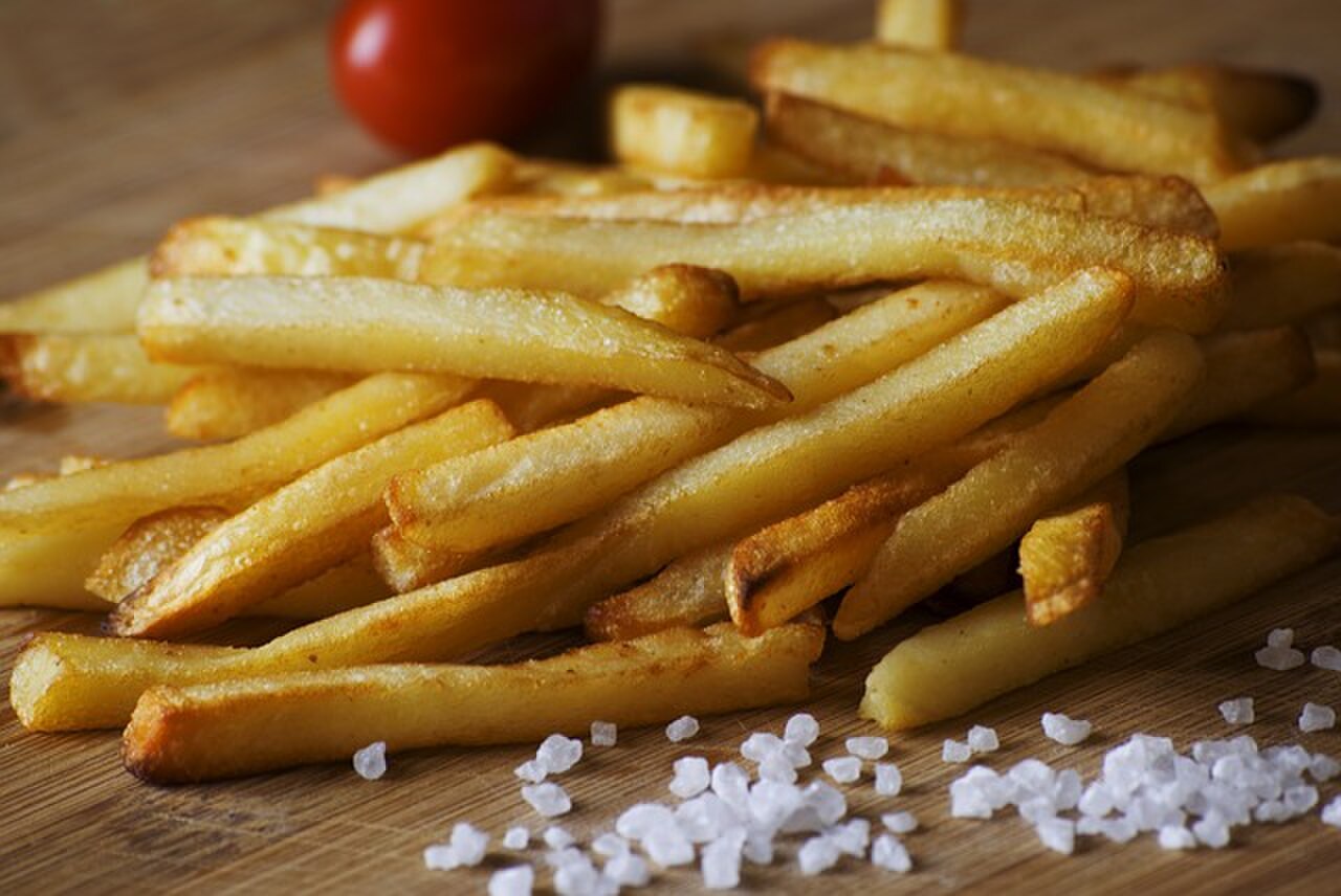 Porção de batatas fritas crocantes com sal grosso